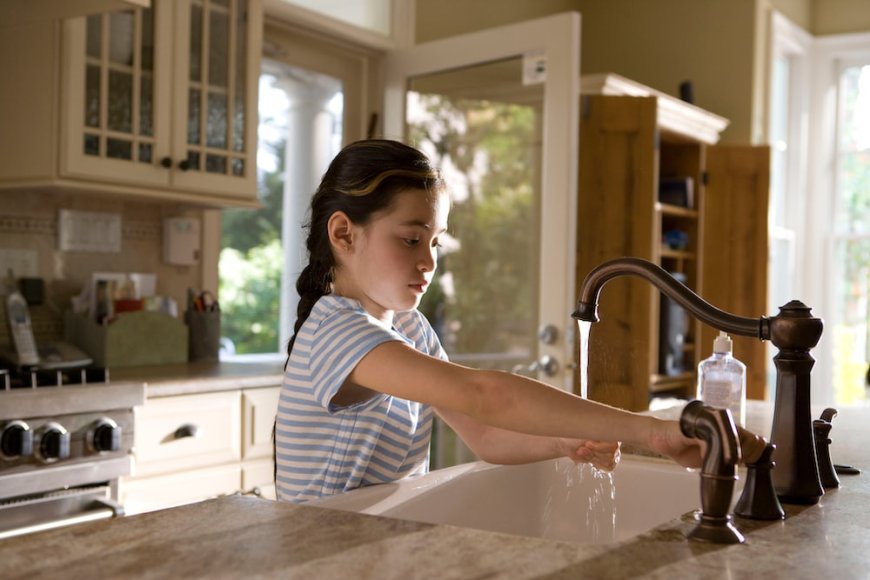 A young child washing hands after plumbing service